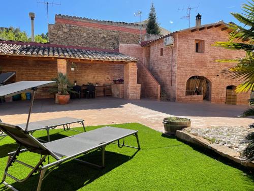 un patio con mesa y banco en Cal General, en Sant Vicenç de Castellet