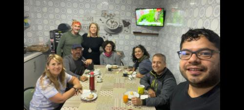 eine Gruppe von Menschen, die um einen Tisch sitzen in der Unterkunft Pensión Casa do Gallo Sarria in Sarria