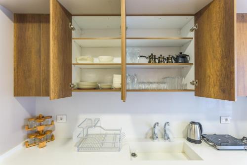 a kitchen with wooden cabinets and a sink at Crest 3-Bedroom Apt in Hamra W- 24-7 Power in Beirut