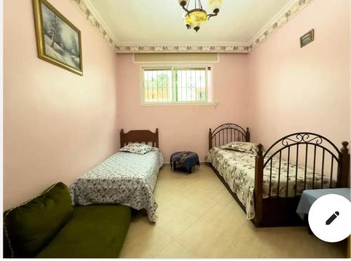 a bedroom with two beds and a couch at Villa calme a tamuda bay médique region de tetuan in M'diq