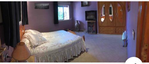 a bedroom with a bed in a room with purple walls at Villa calme a tamuda bay médique region de tetuan in M'diq