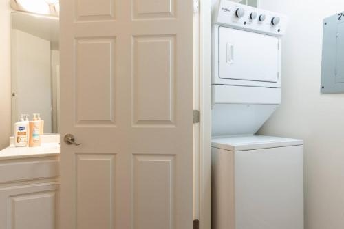 Una puerta blanca en una cocina con lavadora y secadora. en Corporate Housing by MGM en Gurnee
