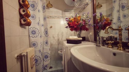 a bathroom with a sink and a vase of flowers at La casa nel Borgo in San Gregorio da Sassola