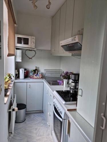 KönigstädtenにあるHelle, komfortabel und zentral gelegene Wohnungの白いキャビネットとコンロ付きオーブンを備えたキッチン