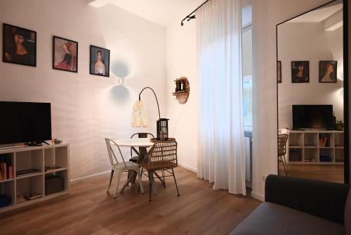 a living room with a table and chairs and a television at Maison Bohémienne in Livorno