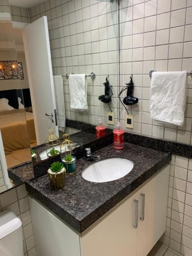 a bathroom counter with a sink and a mirror at FLAT HOTEL BEIRA MAR AV BOA VIAGEM Recife in Recife