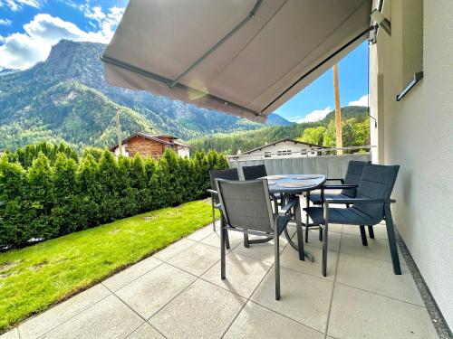 a table and chairs on a patio with a view at Apartments ALPsmart in Oetz