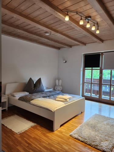 1 dormitorio con 1 cama grande en una habitación con suelo de madera en Ferienhaus Bad Feilbach, en Bad Feilnbach