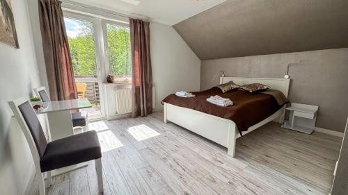 a bedroom with a bed and a desk and a window at Dom Jeziorna Perla in Ośno Lubuskie