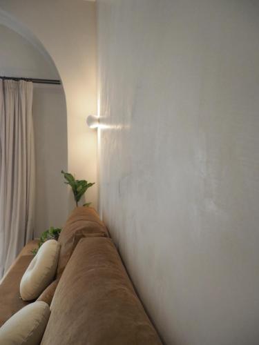 a couch against a white wall with a plant on it at enδόtera chios apartments in Chios