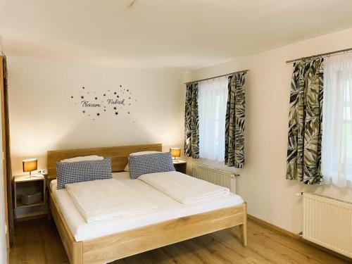 a bedroom with a bed and two windows at Loft Krämerhaus Annaberg, Dachstein West in Annaberg im Lammertal