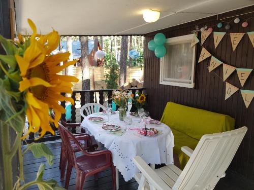 a table with a white table cloth on a porch with a sunflower at POD SOSNAMI Ośrodek Wypoczynkowy Boszkowo Letnisko in Boszkowo