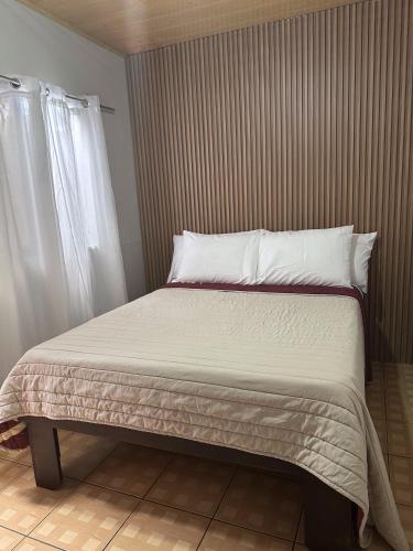 a bed with white sheets and pillows in a bedroom at Casa Buen Agüero in San Antonio