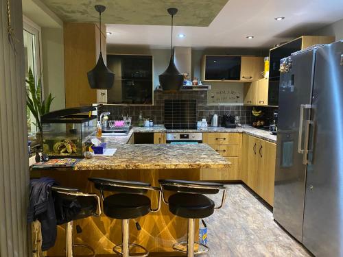eine Küche mit Granitarbeitsplatte und Kühlschrank in der Unterkunft Cozy single room in private home in Dagenham