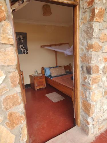 sypialnia z łóżkiem piętrowym w ceglanej ścianie w obiekcie MARK's farm & ecolodge w mieście Kalenga