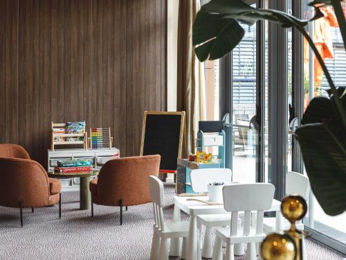 a room with white tables and chairs and a large window at Crowne Plaza Lyon - Cité Internationale in Lyon