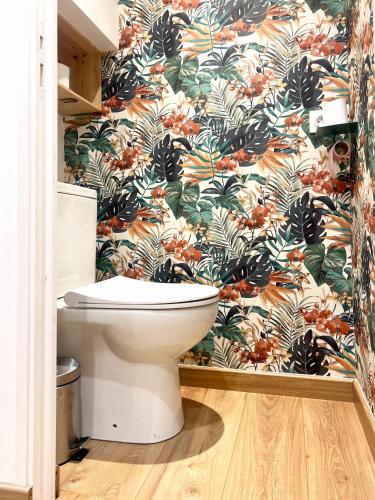 La salle de bains est pourvue de toilettes et de papier peint à fleurs. dans l'établissement Work and Relaxation in Le Havre, au Havre