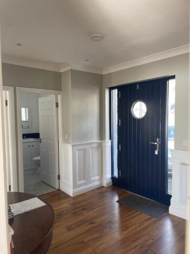 a living room with a blue door and a bathroom at Grianan, Cobh in Cobh