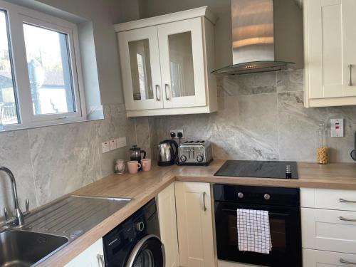 a kitchen with a sink and a stove top oven at Grianan, Cobh in Cobh