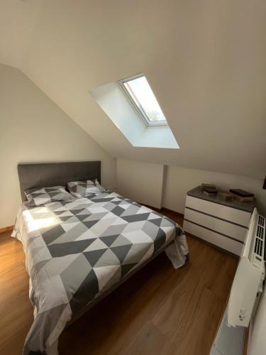 a bedroom with a bed and a skylight at Appartement avec garage in La Ferté-Gaucher