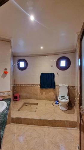 bagno con servizi igienici e lavandino con due finestre di Villa with riad style a Fes