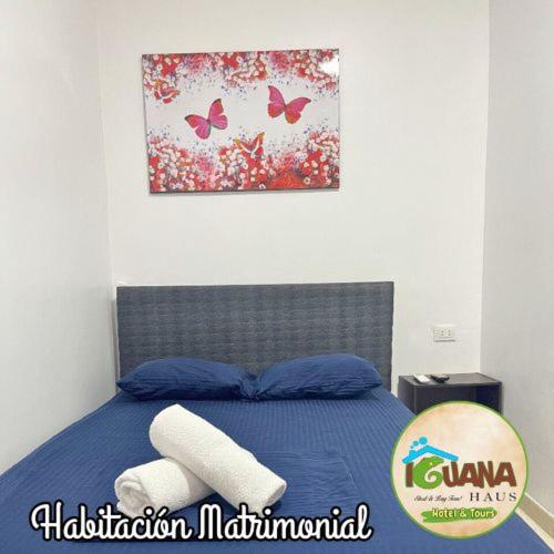 a bedroom with a bed with blue sheets and butterflies at IGUANA HAUS IQUITOS in Iquitos
