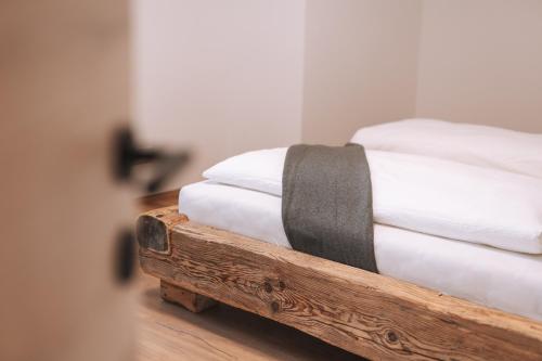 a couple of white pillows sitting on a wooden bed at Matscherhof Lana in Lana