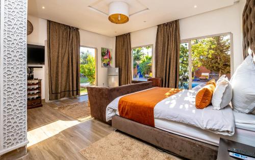 a bedroom with a large bed and large windows at Kasbah Alili in Marrakech