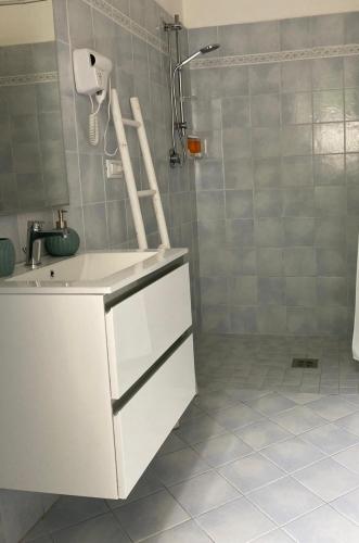 a white bathroom with a sink and a shower at Casa dell'Opera in Pesaro
