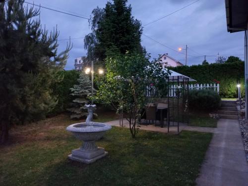 a fountain sitting in the grass in a yard at night at Vila Pogled in Novi Sad