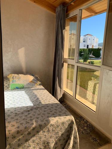 sypialnia z łóżkiem obok okna w obiekcie Achakar w mieście Tanger