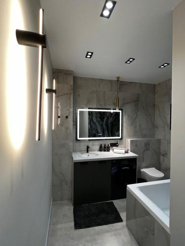 a bathroom with a sink and a toilet and a tub at Lux в ЖК K7-Family рядом аэропорт in Atyraū