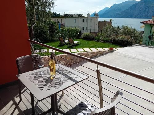 una mesa con una botella de vino en el balcón en appartamentsandreis en Malcesine