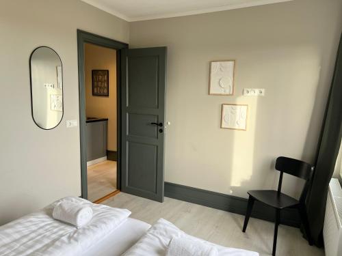 ein Schlafzimmer mit einem Bett, einem Spiegel und einem Stuhl in der Unterkunft The Greyhouse "Small Apartment" in Höfn
