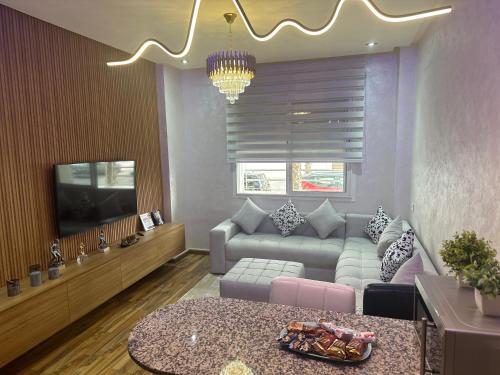 ein Wohnzimmer mit Sofa und Fernseher in der Unterkunft Wood-Finish Home Pool Premium Bedding Self-Check in 7 Min from Marina in Agadir