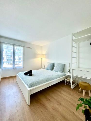 une chambre avec un lit dans une pièce blanche dans l'établissement Suite Victoria Near Disneyland, à Chessy