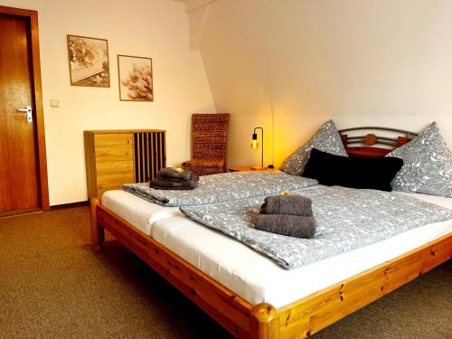 1 dormitorio con cama de madera y almohadas en 3-Zimmerwohnung, 2 Bäder, Büsum (4km), Nordsee en Oesterdeichstrich