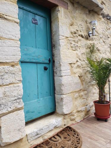 a blue door on a stone building with a potted plant at Le Pigeonnier du Château in Saint-Victor-de-Malcap