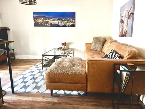 a living room with a brown couch and a glass table at Budapest - Heritage Tay Basin Water View in Perth