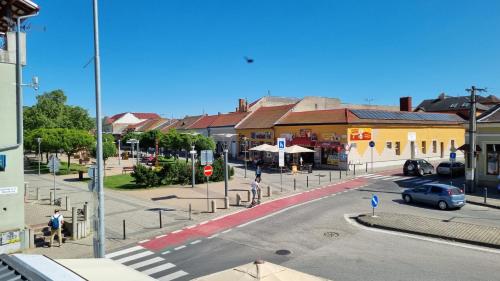 una calle en una ciudad con coches aparcados en la carretera en Elite Pension, en Štúrovo