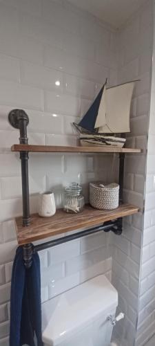 a wooden shelf above a toilet in a bathroom at 5 Main Street in Llangwm