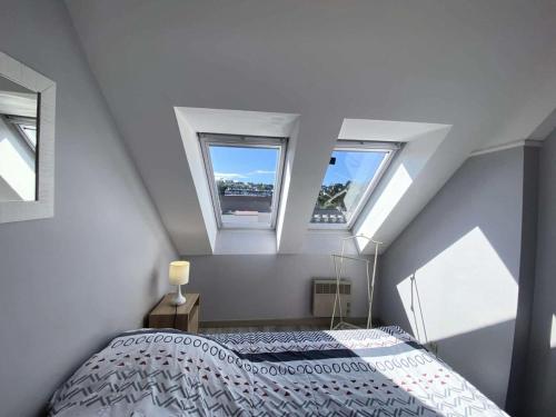 - une chambre avec deux fenêtres et un lit dans l'établissement Résidence Le Casino - Appartement devant la plage vue mer parking privé MAE-6404, à Perros-Guirec