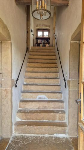 a set of stairs in a building with a chandelier at Noizilly - Propriété jusqu'à 16 personnes avec piscine in Lournand