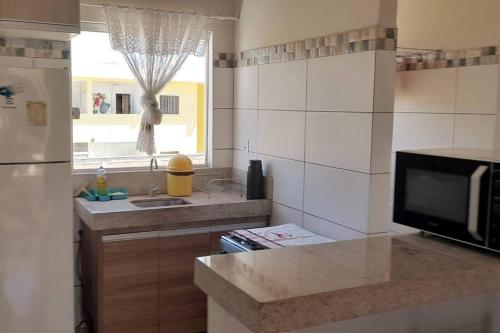 uma cozinha com um lavatório, um micro-ondas e um balcão em Ap Beira Mar Praia do Muta em Coroa Vermelha