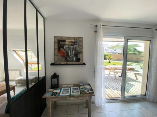 d'un salon avec une table et une porte coulissante en verre. dans l'établissement Résidence S08-tregastel - Maison avec jardin privé près de la mer MAE-4614, à Trégastel
