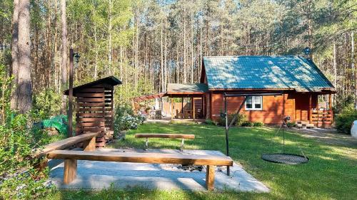 a log cabin with a bench in front of it at Chata przy lesie in Łuka