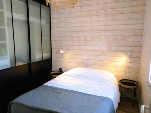a bedroom with a bed and a wooden wall at Résidence S08-tregastel - Maison avec jardin privé près de la mer MAE-4614 in Trégastel