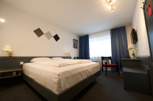 a hotel room with a bed and a window at Hotel Merian in Cologne