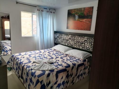 a bedroom with a bed with a blue and white blanket at HOTEL BIG BEN MALAGA SANTANDER in Málaga