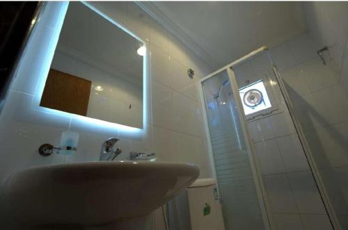 ein Badezimmer mit Waschbecken und Dusche mit Spiegel in der Unterkunft سيزن للوحدات السكنية in Dschidda
